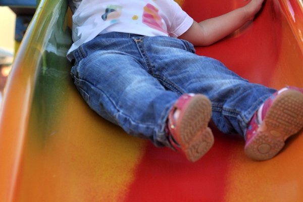 Illustration : un enfant sur un toboggan rouge